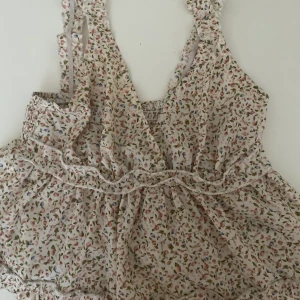 Blommigt volang linne - Gulligt volang linne från shein med beiga blommor på! Perfekt croppad längd 💓 säljes pga lite för liten! Tunnt men väldigt skönt material ;)