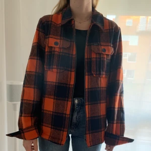 Jacka höst/vinter - Mörkblå- och orangerutig jacka med vitt foder. Jackan har nästan bara blivit liggande sedan jag köpte den och bara använt ett par gånger. Den är alltså så gott som ny