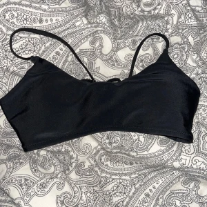 Basic svart bikini topp - Basic svart bikini topp med knäppe därbak från SHEIN. Säljer pga förliten. Den är i stl M men är väldigt liten i stl. Skulle säga att den är Xs. Använd några gånger under denna sommaren.