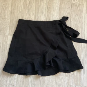 Kjol - Svart omlott kjol med volang och knyte i sidan🥰