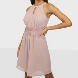 Vila klänning - En helt ny klänning från Vila med lapp kvar! Nyköpspris 399 kr. Den har dekorativ spets runt midjan och är i en ljusrosa färg. Mini längd. Passar perfekt till skolavslutning eller bröllop!   Storlek: 34 Material: 100% polyester Skick: Oanvänd