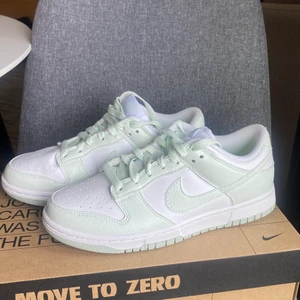 Nike dunk  - W Nike Dunk Low Next Nature  Storlek 7.5 (38.5)  Färgen heter White/Barely Green   Helt oanvända, jag köpte fel storlek så tyvärr kan jag inte använda dom. Otroligt fin grön färg!  