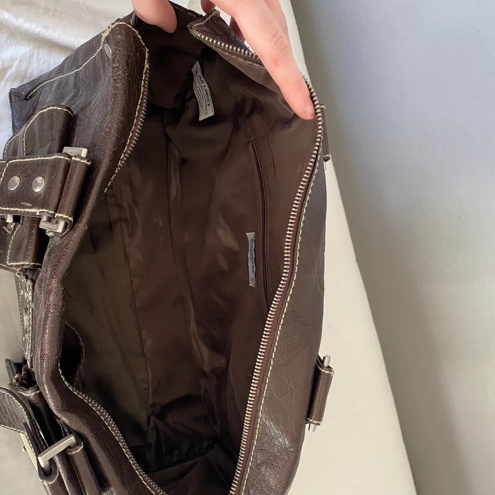 En jättesnygg brun väska med många fack och fina detaljer! I ett fint skick, bara få repor. Får plats med mycket och perfekt nu till sommaren!🌸 34 cm lång, 13cm bred. Väskor.