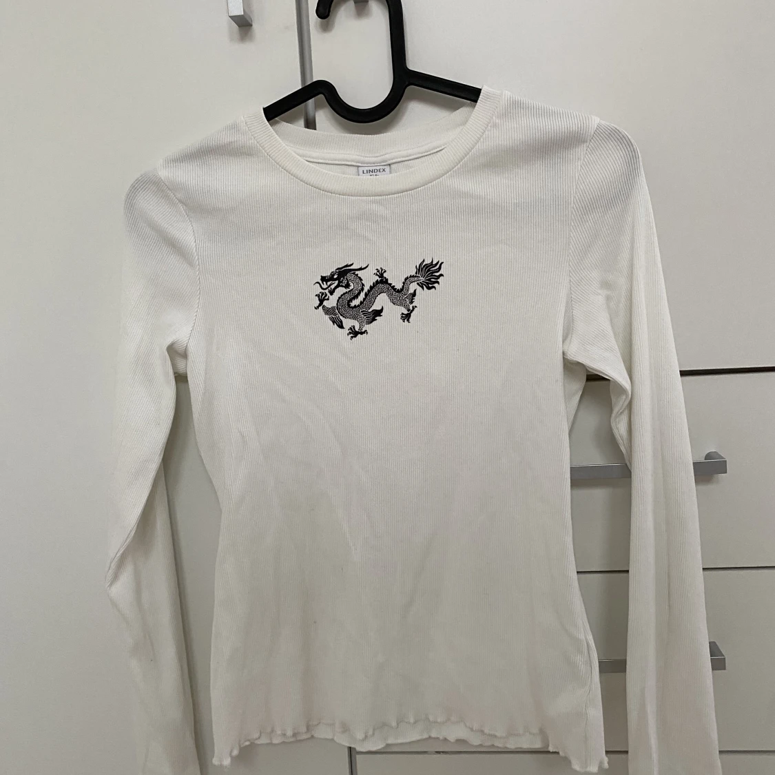 Vit långärmad tröja med en drake