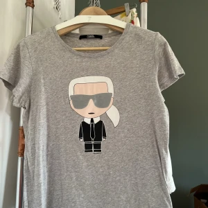 T-shirt Karl Lagerfeld strl M - Karl Lagerfeld: T-shirt i bomull med ”Kalle” på fram- och baksida, strl M  Används för sällan  Ej skråmor eller förändringar i material 