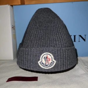 Moncler Mössa - Säljer denna riktigt sköna mössa från moncler till ett riktigt bra pris!! Mössan är använd, men fortfarande i ett gott skick! Köpt på NK, qr kod finns, tyvärr finns inget kvitto. Vid mer funderingar kom privat!
