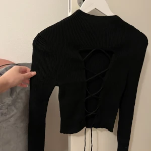 Tröja med öppen rygg  - Säljer denna super snygga tröja med knytning vid ryggen från Gina tricot🤍🤍