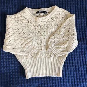 Stickad blus  - En lite kortare stickad tröja som ärmarna räcker ner till armbågarna. Den är från BikBok och har en gul beige nyans.