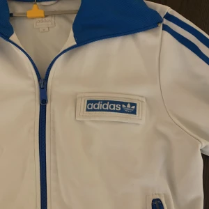 Adidas jacka - Adidas jacka. Storlek 42 men skulle säga att det istället passar 34/36. Finns en liten skada på baksidan av ena armen, bild 3. Annars bra skick