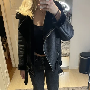 Svart fodrad skinn jacka - Jag säljer min svarta fodrade skinnjacka ifrån Zara, den är i bra skick förutom att lappen är av, men den går bara att klippa bort ✨