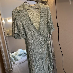 Omlottklänning  - Superfin mönstrad långklänning från Carin Wester i grön och vit. Skriv för mer bilder. Storlek 34, men sitter bra på mig som vanligtvis har 36-38. Sparsamt använd och i mycket bra skick🥰