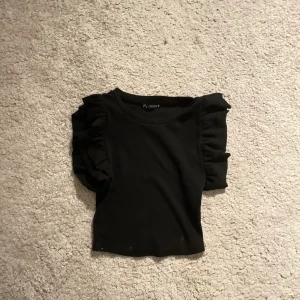 Svart tröja med volanger - Nu säljer jag min super fina volang t-shirt från zara, vet inte om den säljs längre. Säljer denna då den inte kommit till andvändning och då jag behöver pengar.