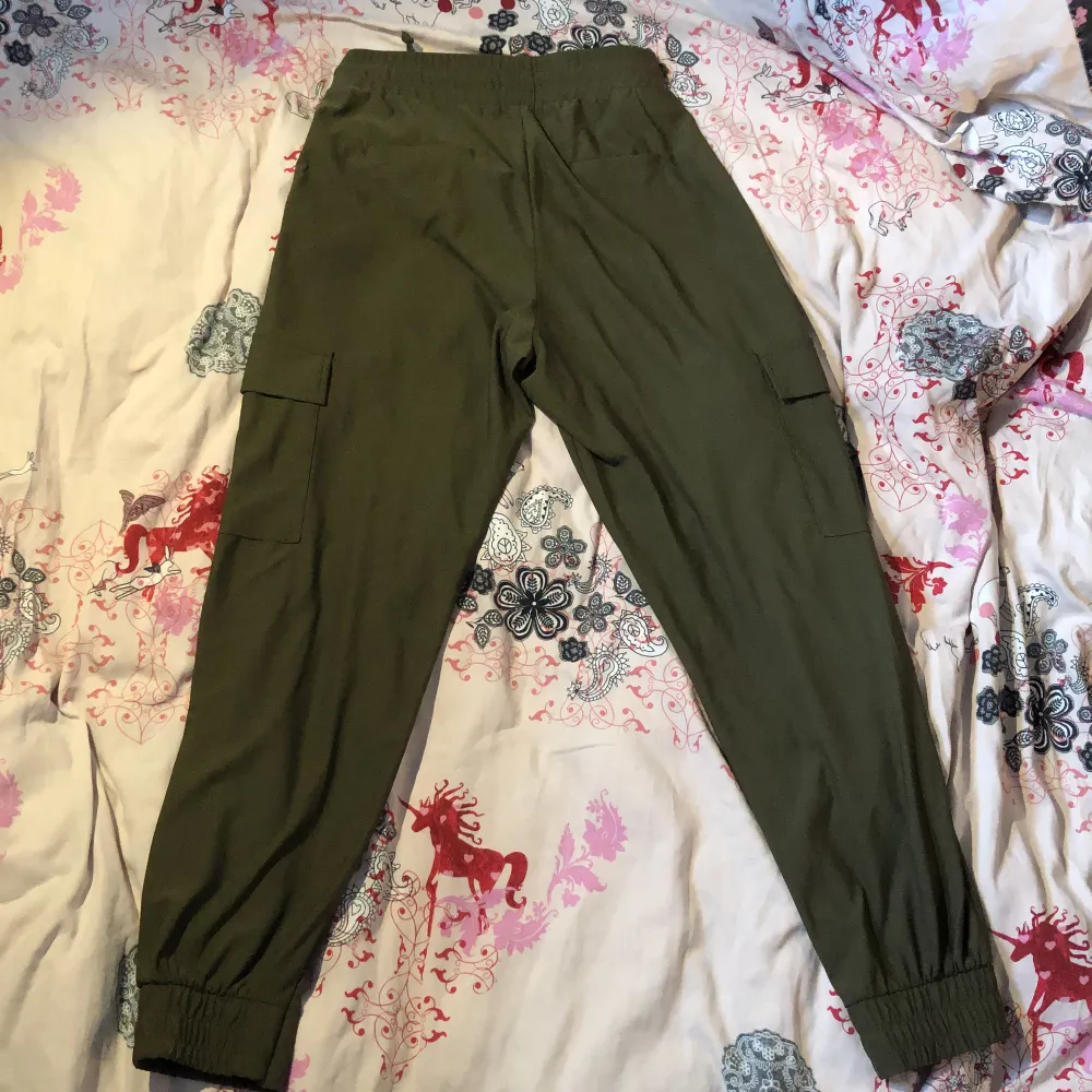 Gröna byxor i polyester. Kom på att de va lite små efter jag köpt dem. De är ganska tunna men väldigt sköna och har 4 bra fickor. Storlek S. Jeans & Byxor.