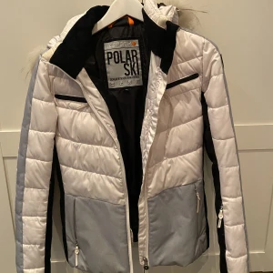 Vinterjacka  - Polarski vinterjacka storlek 36  Vit och grå. Väldigt varm och skön! Många olika fickor finns  Nypris runt 1500kr 