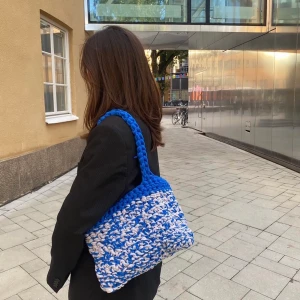 By Naemi ”Eda” väska - Denna fina väska är virkad av 100% återvunnet material♻️❤️‍🩹  Rymmer allt nödvändiga samt en dator💻✌🏼Väskan går att få i önskad färg/färger!!🤍🤍 Väskorna görs on demand, hör av er för beställning🤍♻️Glöm ej kolla vårt flöde för fler modeller och färger♻️🤍✌🏼