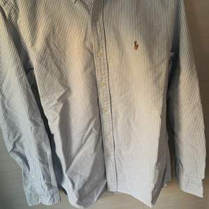 Ralph lauren skjorta i nyskick, nypris ca 1200 och i storleken M. Den är vit med ljusblåa ränder