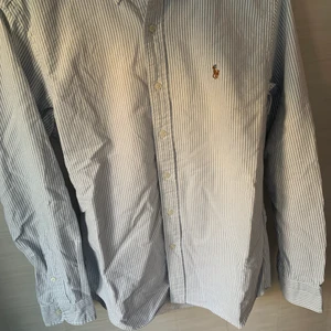 Ralph Lauren skjorta i vitrandig - Ralph lauren skjorta i nyskick, nypris ca 1200 och i storleken M. Den är vit med ljusblåa ränder