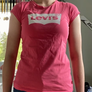 Rosa Levis T-shirt Strl 158/Xs - En rosa T-shirt med ganska korta armar. Har inte använt tröjan mer än 1-2 gånger då jag inte tyckt den varit min stil. Säljer den eftersom den är för liten för mig nu.