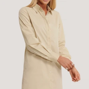 Beige klänning - Säljer denna fina skjortklänningen ifrån AFJ Nakd i storlek 36. Aldrig använd och lappen kvar! 