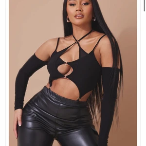 Svart festival crop top bodysuit - Säljer en väldigt cut out bodysuit från PrettyLittleThing då jag inte riktigt känner den va min stil. Köptes för £19 ≈ 235kr men säljer för billigare då det är ett produktionsfel. Den går inte att stänga där nere eftersom dem satt samma knapp 2 gånger. Så alternativet är att antingen ändra till den som saknas, eller sy igen eller ta bort underdelen och ha det som en nice crop top istället!✨ Denna är aldrig använd bara testad. Storleken är S men skulle nästan säga att xs är att rekommendera.
