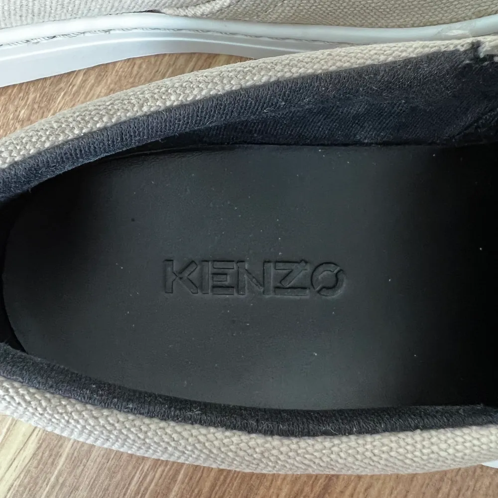 Kenzo slip on skor i storlek 36, deras skor är en storlek större så har du storlek 37 som mig så passar 36. Använda max 7 gånger och köpta förra året för Kenzos egna hemsida. Dustbag finns kvar. Säljer eftersom de inte kommer till användning. Skorna är i en beige färg. Pris går att diskuteras.. Skor.