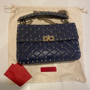 Valentino väska - Säljer min fina marinblåa valentino rockstud väska i storleken medium. Väskan har används flitigt men är fortfarande i mycket gott skick. Nypris 20.000 kr men eftersom det är en slitning på lädret inne i väska så säljer jag väskan för 12.000kr. Vid fler frågor är det bara att höra av sig!❤️