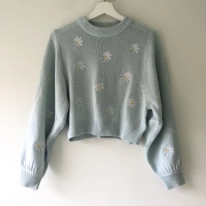 Stickad tröja med blommor - Stickad tröja i kortare modell med blommor! Något nopprig men fortfarande väldigt fint skick.