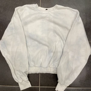 Sweatshirt  - Säljer en vit sweatshirt med ljus blå ”fläckar” med resorband i midjan