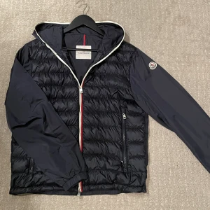 Moncler cardigan  - Säljer min moncler cardigan som är i jättebra skick! Skick 8/10 förutom en liten lagning, se bild 3. Men det är inget som syns eller märks! Självklart äkta!  Hör gärna av dig om du har frågor! 