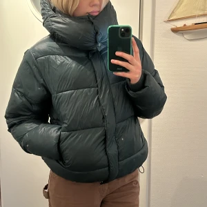 Mörkgrön Dunjacka - En supergo dunjacka under vintern och otroligt snygg. 💚Är lite glansig och mörkgrön i färgen. Avtagbar luva. Från början från Bikbok. Bra skick! Storlek XS men stor i storleken så är som en small. Köpare står för frakten!📦