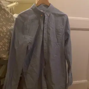 En ljusblå ASKET skjorta I storlek M