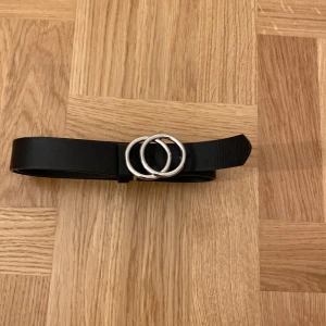 Svart bälte  - Ett svart bälte, används en gång, tyvärr är det klippt ett extra hål, men syns inte särskilt mycket. 20kr + frakt