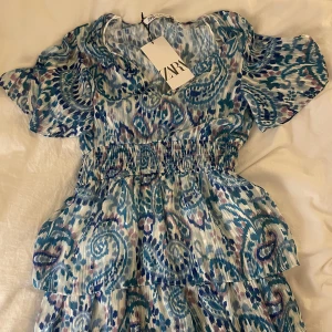 Zara klänning blå med mönster - Säljer denna slutsålda zara klänning med mönster 💞 den är ovanvänd med lapp kvar 💞