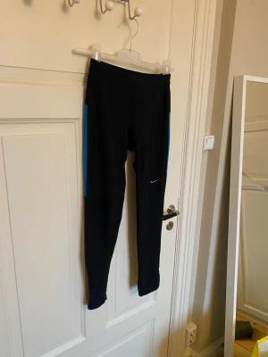 Träningstights från Nike - Säljer ett par snygga träningstights från Nike. Storlek S. Givetvis äkta. I använd skick, men är i gott skick. Dragkedja nedtill. 92% polyester och 8% elastan. 