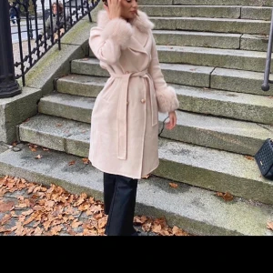 Beige kappa med päls  - En beige lyxig kappa med päls detaljer. Använd endast en gång för att ta bilder. Från Nobelcopenhagen. Köpt för 3000 kr.