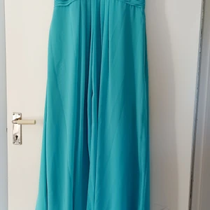 Turkos Balklänning  - Säljer min fina balklänning, använd 1 gång. Axelbandlös med inbyggd bh. Fint skick