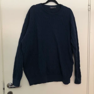 Kabelstickad tjocktröja i strl 3XL - Tjocktröja i mörkblå färg från dressman, storlek 3XL. I använt skick då tyget har blivit väldigt mjukt genom tvätten. Utan hål eller fläckar dock. Köparen står för frakt men dm:a gärna vid frågor eller funderingar. 