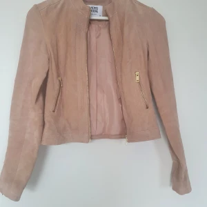 Skinnjacka  - Helt ny skinnjacka från Vero Moda. Oanvänd. Färg gammal rosa/ beige. Storlek XS. Mocka.