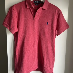 Röd/Rosa ralph lauren pike tröja - Det är en röd/rosa Ralph lauren pike tröja som inte längre används. Det är barnstorlek M.