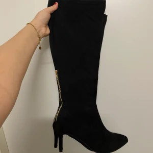 Boots, stövlar - Ett par bekväma nästan kneehigh boots, klackarna är ej höga, går att gå länge i skorna. Kan användas till vardags eller till fest/utgång. Tyget är typ velvet, guld kedja som detalj bakom. Storlek 39 men känns som 38 (jag har Stl 38). Väldigt fint skick