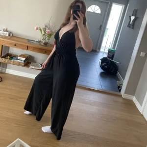 Jumpsuit - Uppklädd jumpsuit med öppen rygg. Linnetyg med snörning i midjan som gör passformen lätt att justera. Bra längd (för referens är jag 170cm)