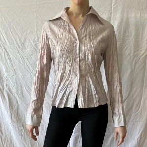 Tunn ljusrosa skjorta - Tunnt fint tyg. Ljusrosa nyans. Fint veckad och med lite passform. Sparsamt använd. 