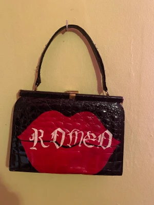 väska - handväska i orm liknade mönster som det står romeo på bredd 28cm höjd 20cm