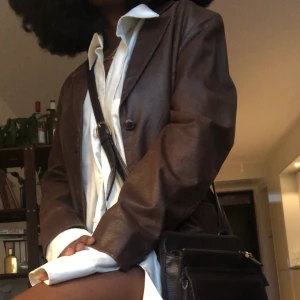 Retro kappa - Vacker brun retro kappa med knappar. Är äldre och därmed lite sluten på vissa ställen (se sista bilden) vilket ger den en äkta vibe, anrs perfekt! Har storlek S/M och jag som själv bär storlek S/M får plats med en tjocktröja under utan problem.