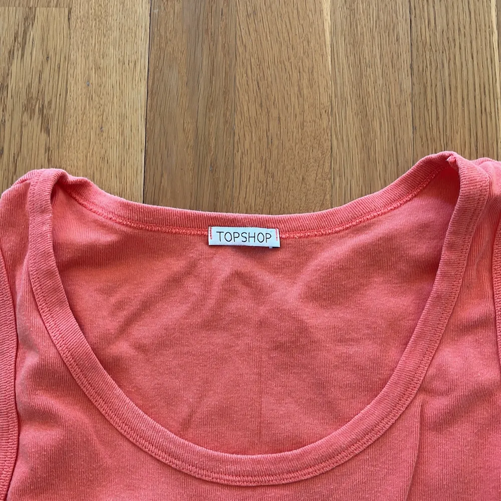 Ett linne i korall/rosa färg från märket topshop. Syns att det är använt men fortfarande i bra skick. Köparen står för frakten . Toppar.