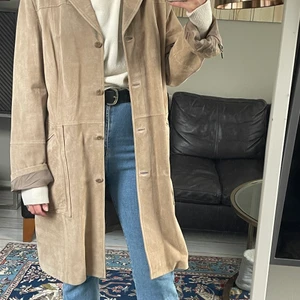 Läderkappa  - Beige läderkappa i storlek 46/48, skulle säga att den sitter som en storlek 40. Jag har s/m i kläder, se bild för egen uppfattning. Äldre men väl omhändertagen, gott skick.