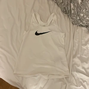 vitt träningslinne från nike - säljer mitt vita träningslinne från nike då jag knappast tränar. det står att det är storlek L men sitter som det vore en S. väldigt fin och skön men den kommer ej til användning. köparen står för frakt 