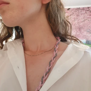 Ett flätat pärlhalsband i rosa och grått. -  Ett mycken fint och elegant halsband i bra skick och fina färger. Finns i endast en storlek.