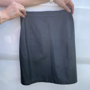 Läder kjol - Äkta läder kjol. Sparsamt använd. Tajt passform.  Pris 250 kr plus frakt Om flera är intresserade blir det budgivning (I kommentarerna) 