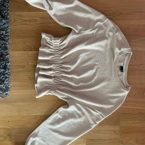 Volang topp - Stretchig beige / puderrosa tröja med resår volang där nere. I storlek xs, men fungerar bra som S med då den är stretch 